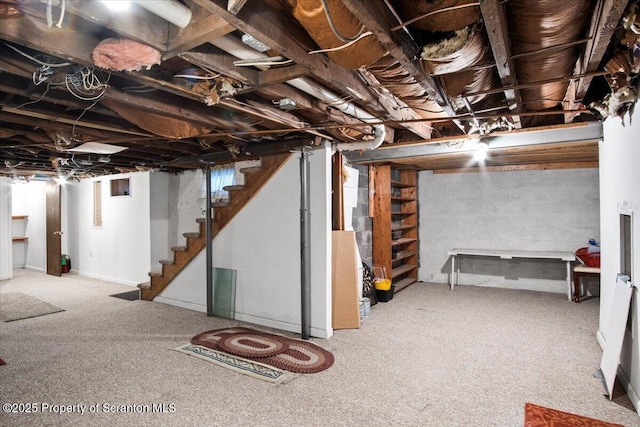 below grade area featuring carpet flooring and stairs