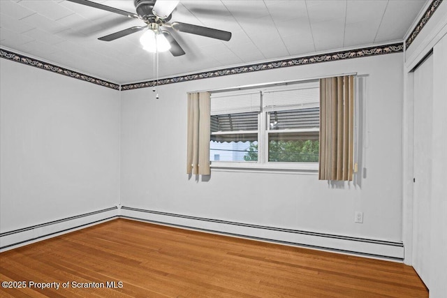 unfurnished room featuring a baseboard heating unit, a ceiling fan, and wood finished floors