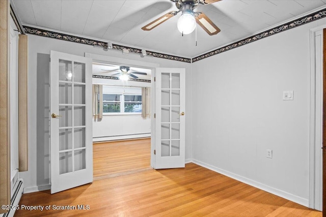 spare room with french doors, a baseboard heating unit, ceiling fan, and light wood-style flooring
