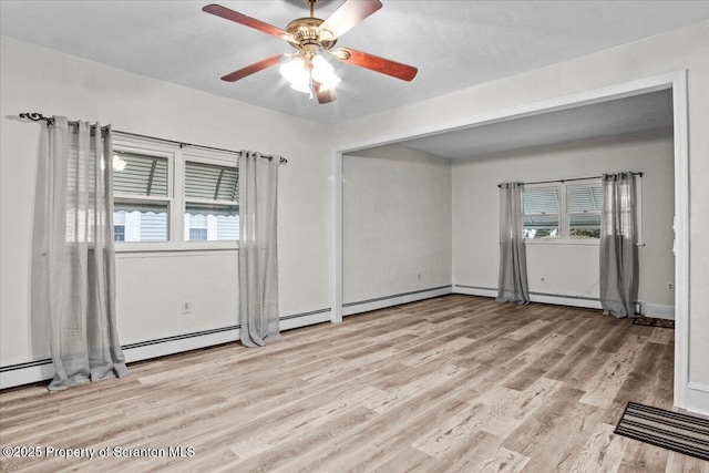interior space with ceiling fan, baseboards, light wood-type flooring, and visible vents