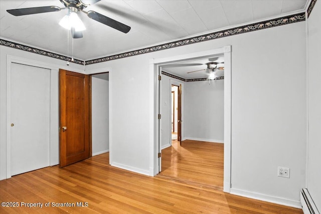 unfurnished bedroom with ornamental molding, baseboards, light wood-type flooring, and baseboard heating