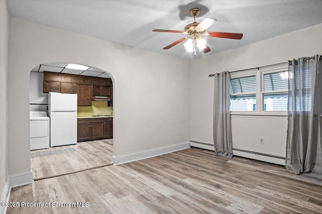 interior space featuring ceiling fan, light wood-type flooring, baseboards, and arched walkways