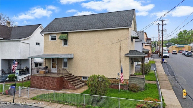 exterior space with stucco siding, a shingled roof, fence private yard, and a gate