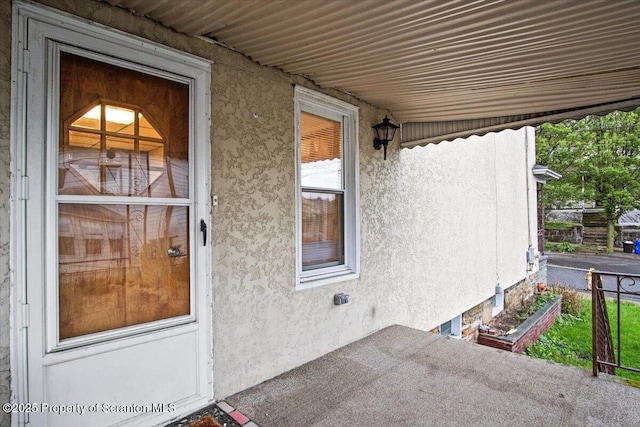 doorway to property featuring stucco siding