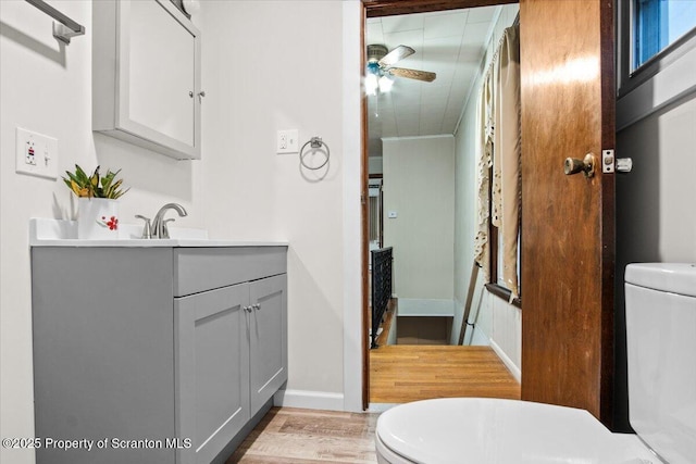 bathroom with vanity, toilet, a ceiling fan, and wood finished floors