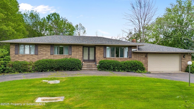 32 Christy Ln, Scott Twp, PA 18447 - ranch-style home with an attached garage, asphalt driveway, brick siding, a front lawn, and french doors