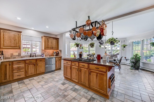 kitchen with tasteful backsplash, light stone countertops, sink, and hanging light fixtures