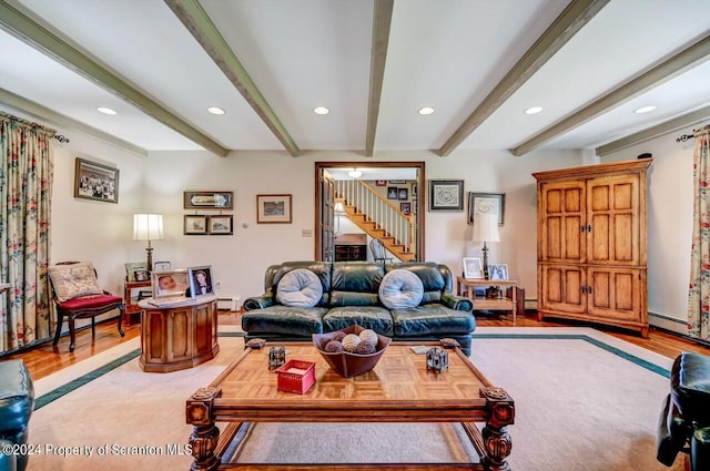 living room with beam ceiling, light wood-type flooring, and a baseboard heating unit