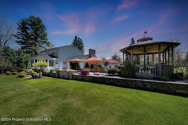 yard at dusk with a gazebo and a patio