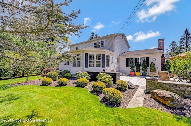 rear view of property with a lawn and a patio