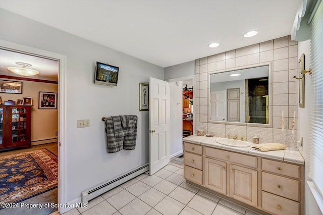 bathroom with tile patterned flooring, vanity, a baseboard heating unit, and backsplash