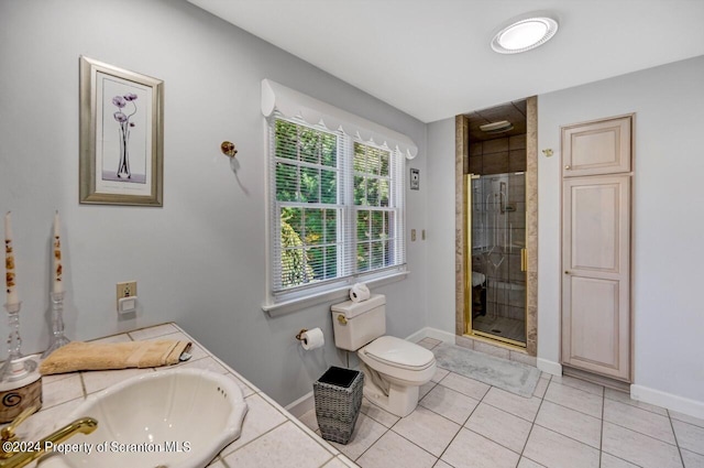 bathroom featuring toilet, vanity, tile patterned floors, and a shower with door