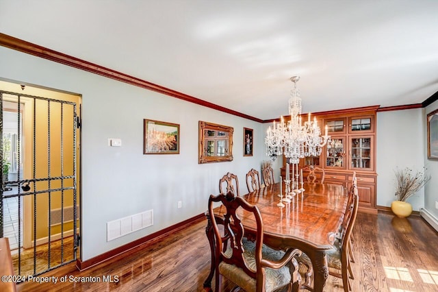 dining space featuring dark hardwood / wood-style floors, crown molding, and an inviting chandelier