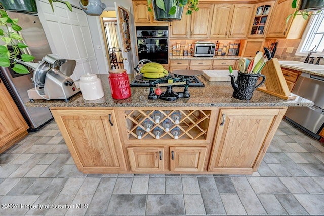 kitchen featuring light stone counters, sink, light brown cabinets, and appliances with stainless steel finishes