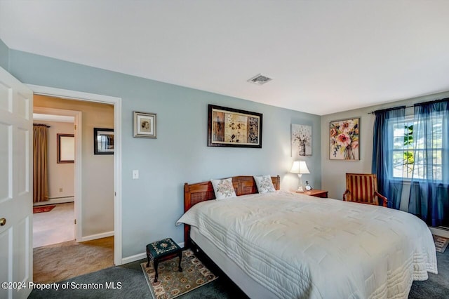 carpeted bedroom featuring a baseboard heating unit