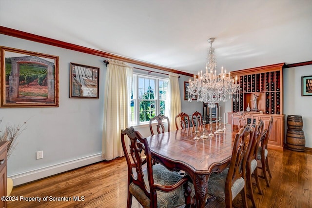 dining space featuring crown molding, wood-type flooring, a chandelier, and a baseboard heating unit