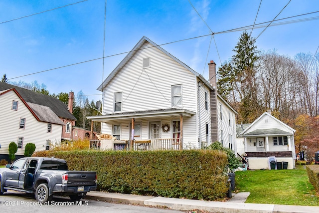 view of front of house featuring covered porch and a front yard