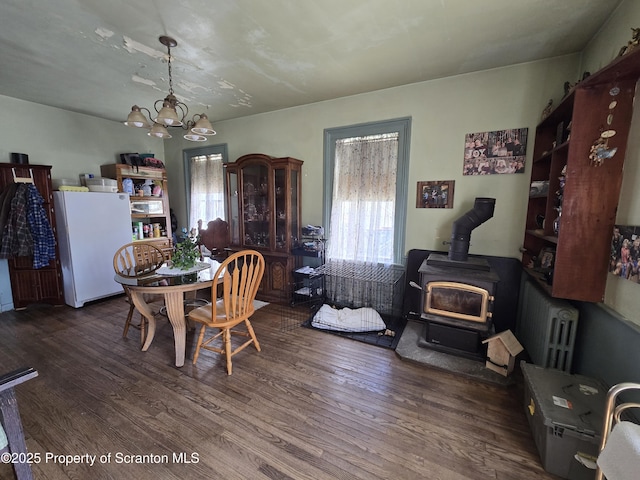 4 Little Ireland Rd, Starrucca, PA 18462 - dining area featuring radiator heating unit, a wood stove, wood finished floors, and a chandelier