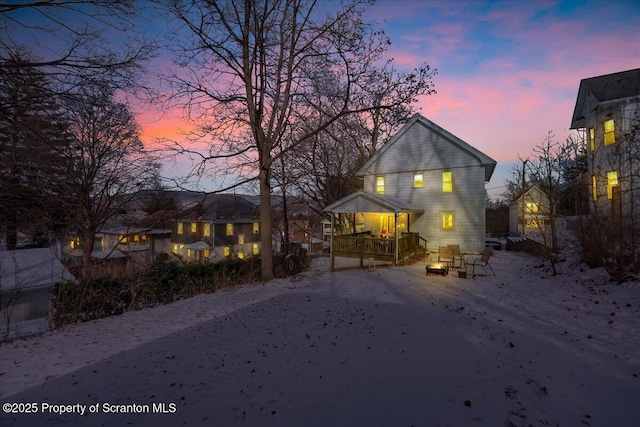 back house at dusk with covered porch