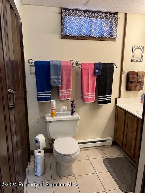 bathroom with vanity, a textured ceiling, baseboard heating, tile patterned flooring, and toilet