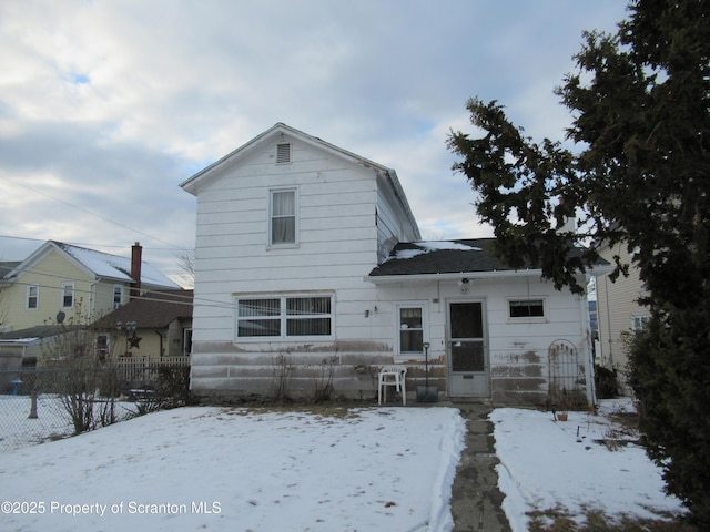 view of snow covered back of property