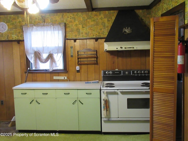 kitchen with wall chimney range hood, wood walls, ceiling fan, and range with two ovens