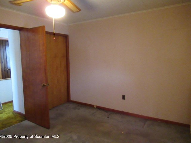 carpeted empty room with ceiling fan and ornamental molding