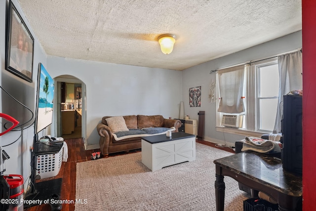 215 St Fr Cabrini Ave Unit Fr, Cabrini, Scranton, PA 18504 - living room with arched walkways, wood finished floors, a textured ceiling, cooling unit, and radiator heating unit