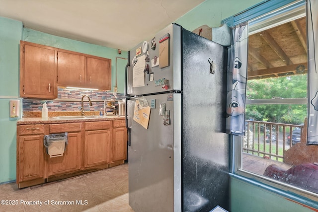 215 St Fr Cabrini Ave Unit Fr, Cabrini, Scranton, PA 18504 - kitchen with freestanding refrigerator, backsplash, light countertops, and brown cabinetry