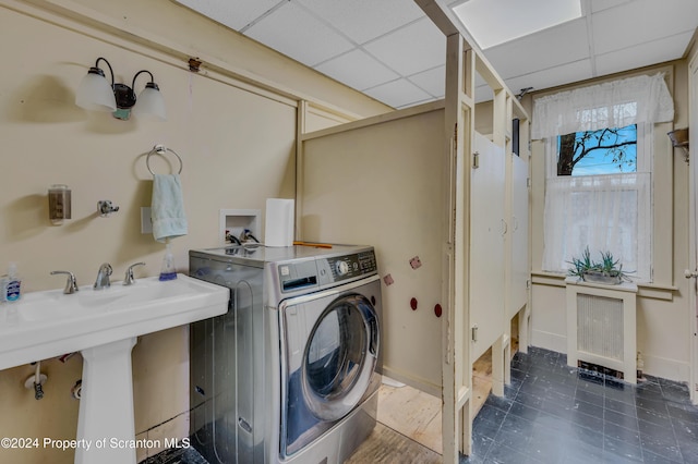 laundry area featuring washer / clothes dryer, radiator heating unit, and sink