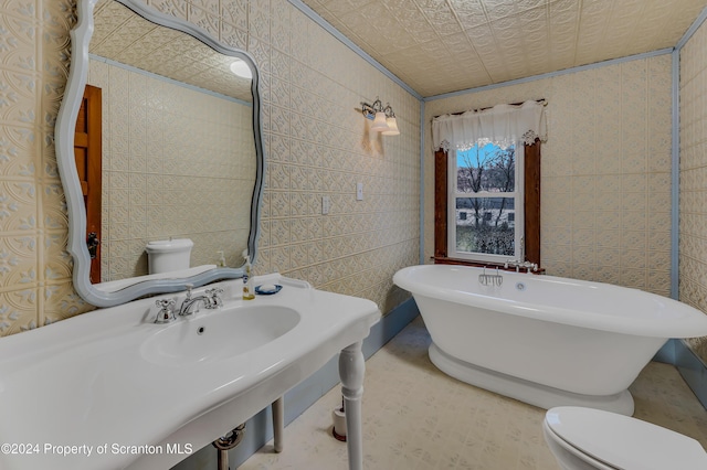 bathroom featuring sink, a bath, tile walls, and toilet