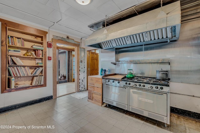 kitchen featuring range hood, built in features, range with two ovens, and ornamental molding