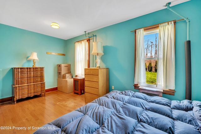 bedroom with wood-type flooring and multiple windows