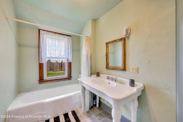 bathroom featuring tile patterned flooring and a bath