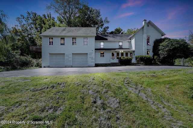 view of front of home with a yard and a garage