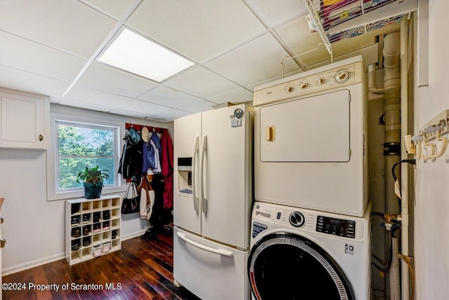 laundry room with dark hardwood / wood-style floors and stacked washer / dryer