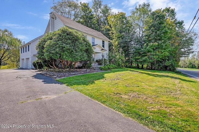 view of side of property featuring a yard and a garage