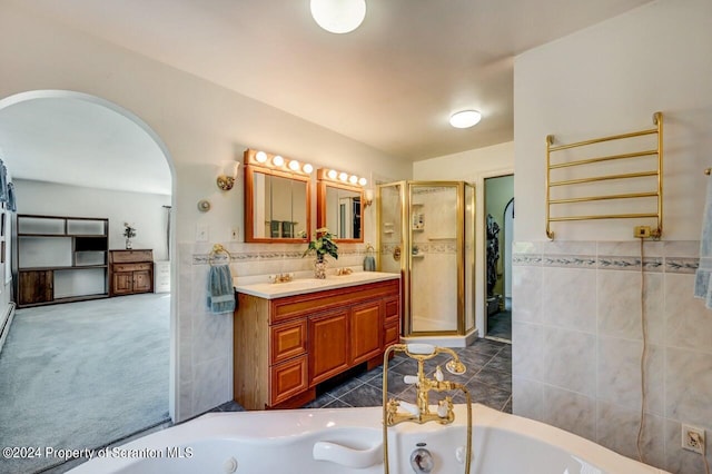 bathroom with vanity, tile walls, and shower with separate bathtub