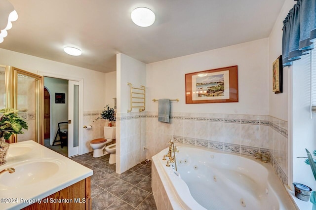 bathroom featuring vanity, a bidet, a relaxing tiled tub, toilet, and tile walls