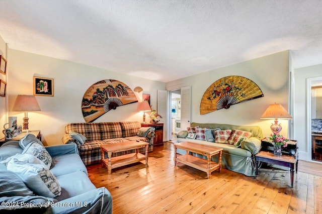 living room with light hardwood / wood-style floors and a textured ceiling