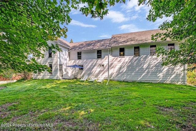 back of property featuring a yard