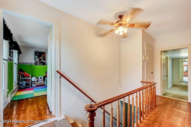 corridor with baseboard heating and hardwood / wood-style floors