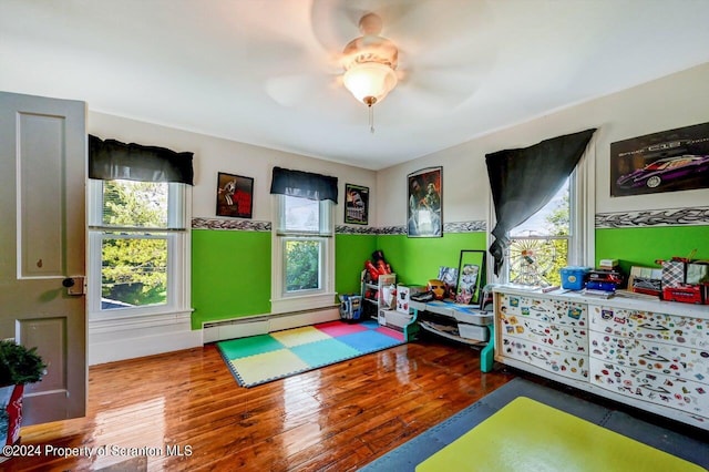 interior space featuring hardwood / wood-style floors, ceiling fan, and baseboard heating