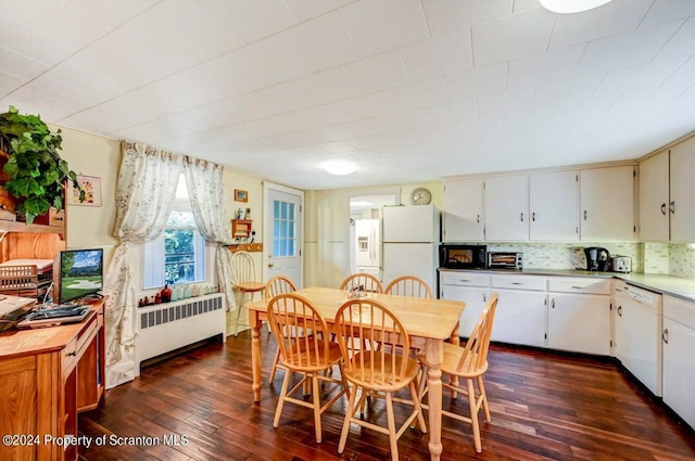 dining area with radiator heating unit and dark hardwood / wood-style floors