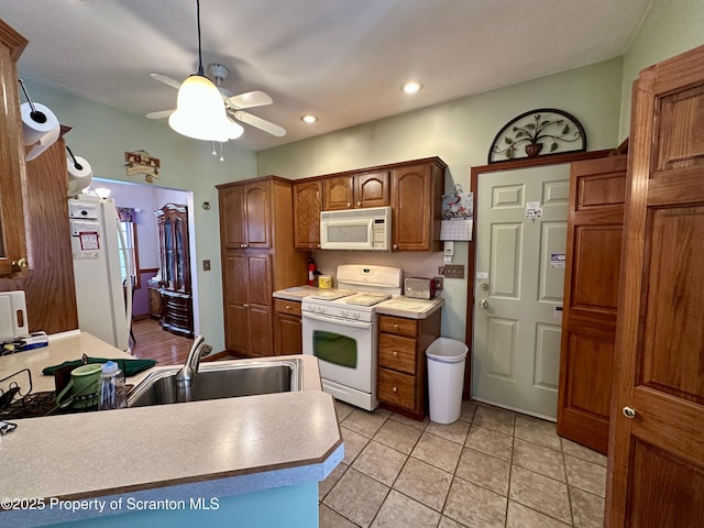 kitchen with ceiling fan, white appliances, sink, and light tile patterned floors