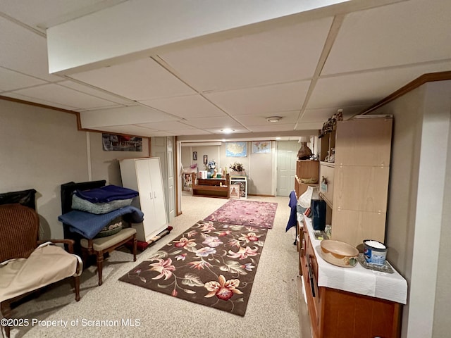 interior space featuring a paneled ceiling and light carpet