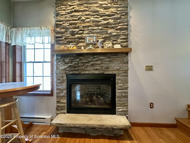 details featuring a baseboard radiator, a fireplace, and hardwood / wood-style floors