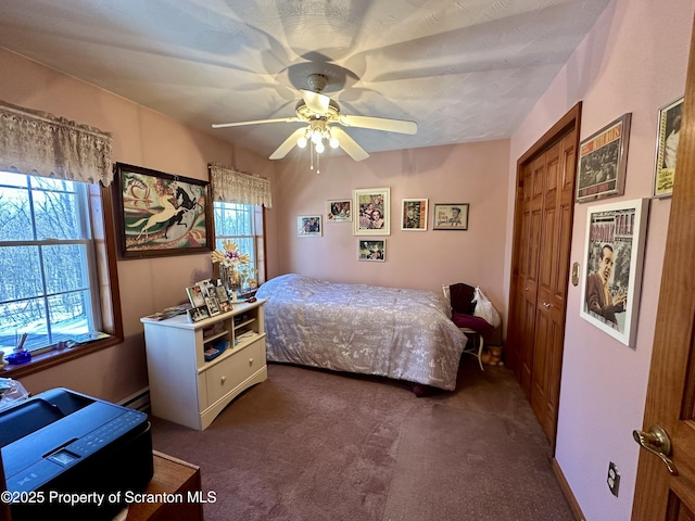 carpeted bedroom featuring ceiling fan, a closet, a baseboard radiator, and multiple windows