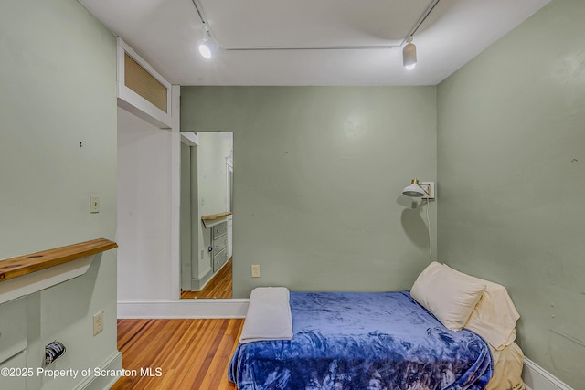 837 Old State Rd, Waverly Twp, PA 18411 - bedroom with rail lighting, wood finished floors, and baseboards