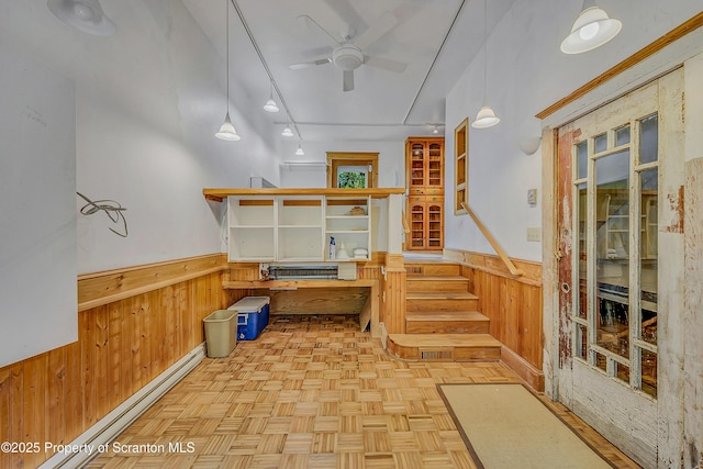 837 Old State Rd, Waverly Twp, PA 18411 - below grade area featuring a wainscoted wall, wooden walls, a ceiling fan, and baseboard heating